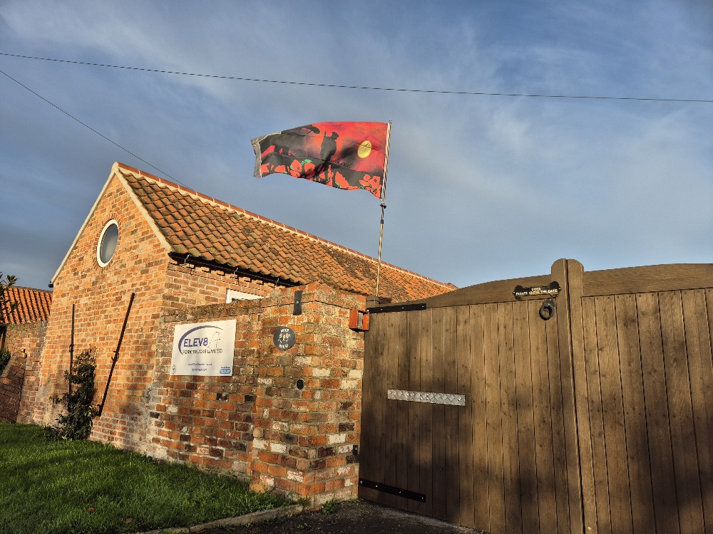 Brick entrance, wooden gate and ELEV8 sign